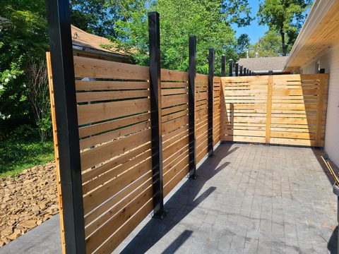 Horizontal-slat privacy screens on black steel posts in Northwest Arkansas