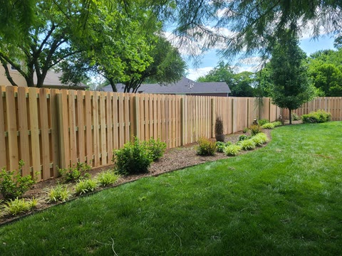 Board-on-board cedar privacy fence along a landscaped backyard in Northwest Arkansas