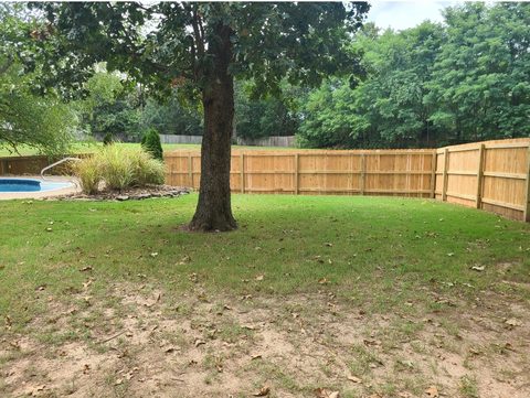 Cedar privacy fence around a backyard with a swimming pool in Northwest Arkansas