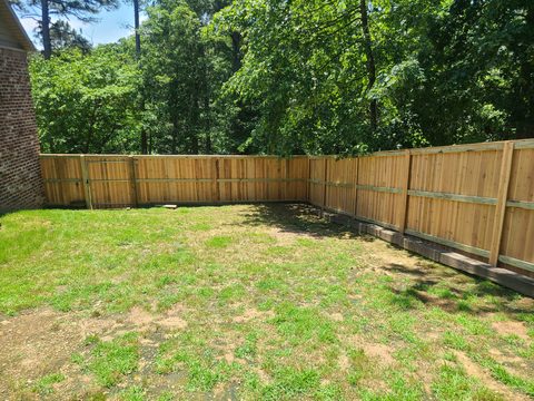 Board-on-board cedar privacy fence enclosing a backyard in Northwest Arkansas
