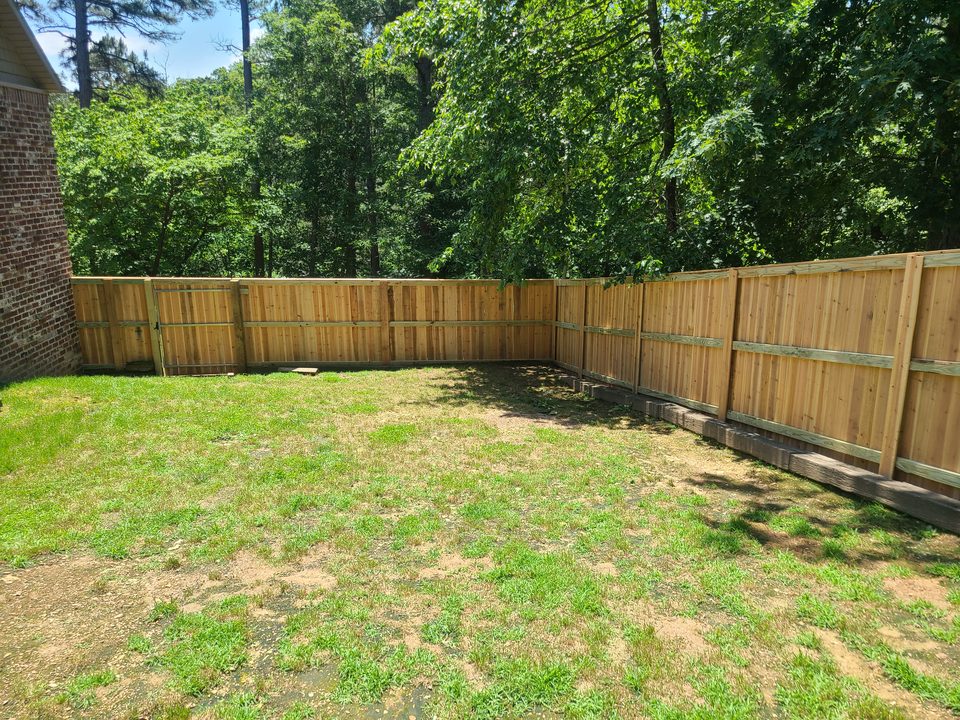Board-on-board cedar privacy fence enclosing a backyard in Northwest Arkansas