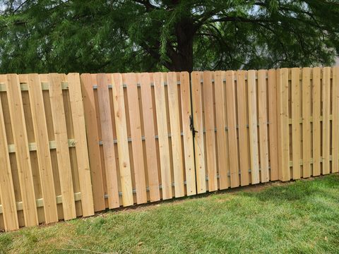 Shadowbox cedar fence with a matching wood gate in Northwest Arkansas