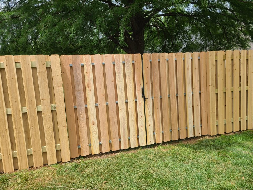 Shadowbox cedar fence with a matching wood gate and latch in Northwest Arkansas