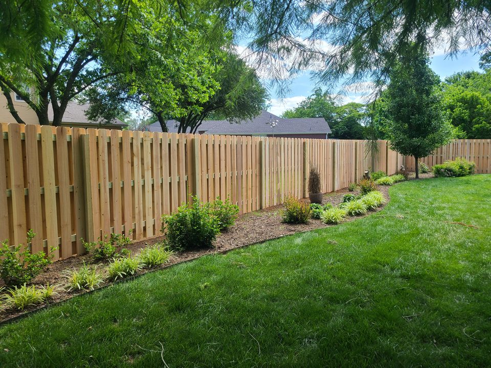 Shadowbox cedar privacy fence with fresh landscaping in Northwest Arkansas